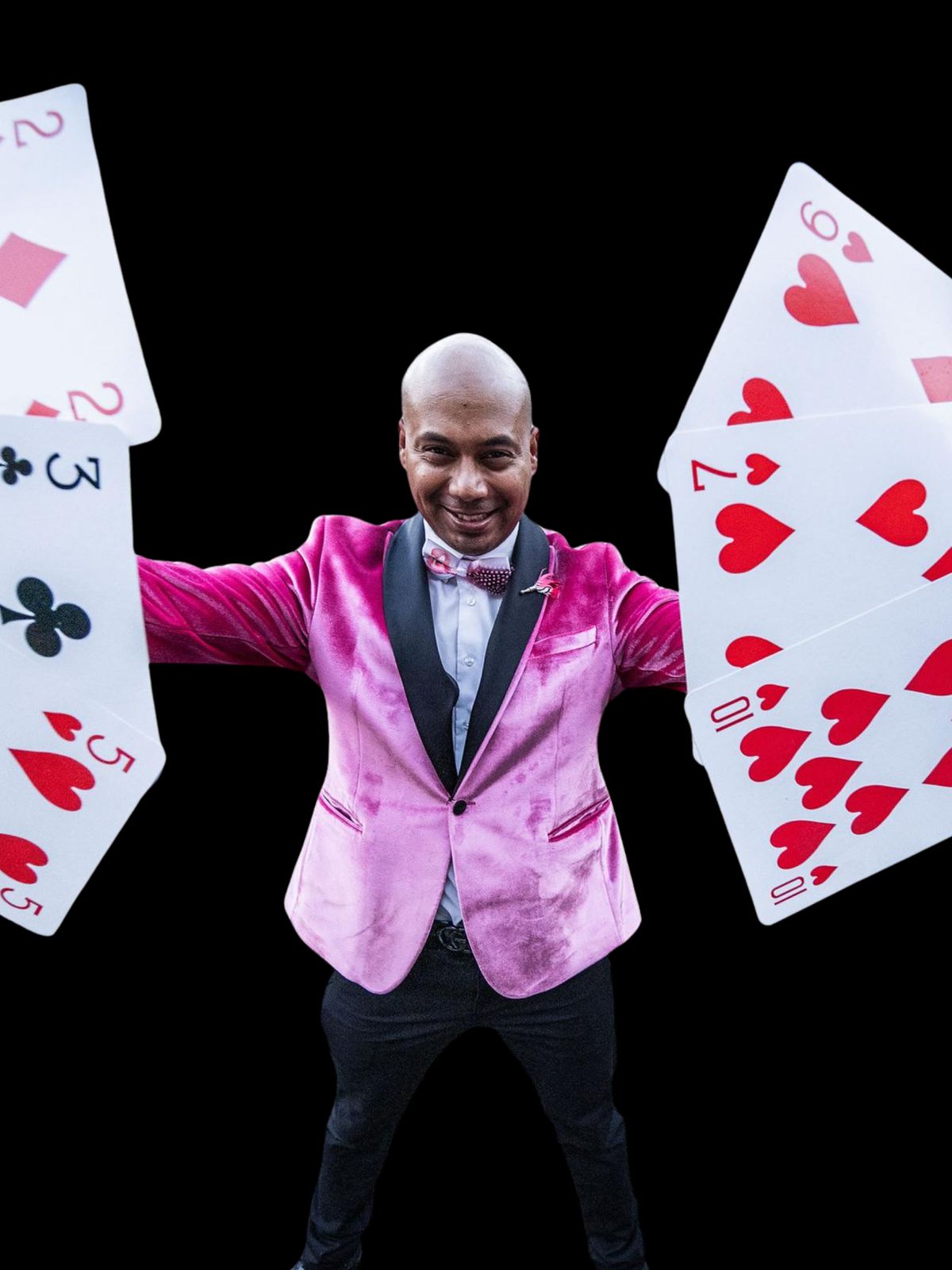 Magician in a pink jacket with giant fanned playing cards
