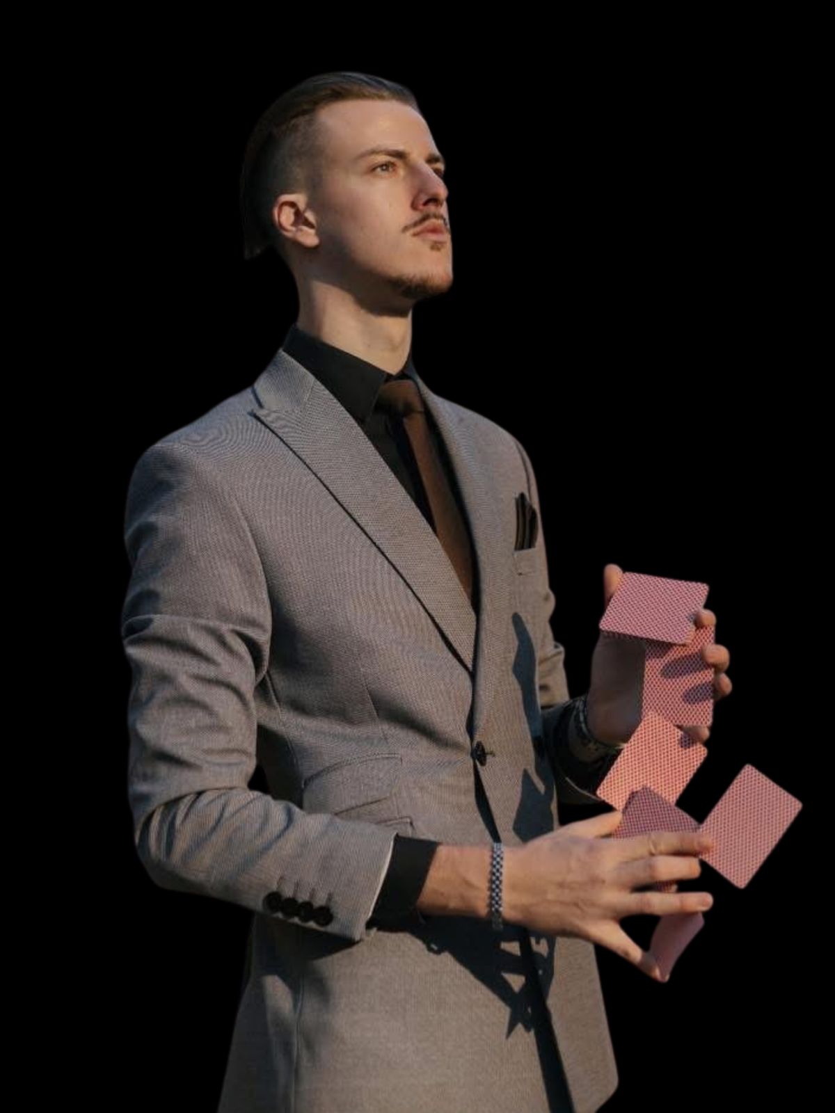 Card manipulation by a mentalist in a grey suit